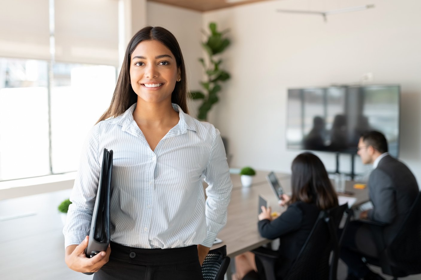 Hispanic female business professional in office boardroom